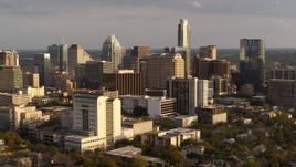 5.7K aerial stock footage of passing a courthouse and office buildings near skyscrapers at sunset in Downtown Austin, Texas Aerial Stock Footage | DX0002_104_042