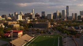 5.7K aerial stock footage a view of skyscrapers and office buildings at sunset in Downtown Austin, Texas, descend by football stadium Aerial Stock Footage | DX0002_105_004