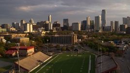 5.7K aerial stock footage of skyscrapers seen while descending to football field at sunset in Downtown Austin, Texas Aerial Stock Footage | DX0002_105_006