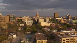 5.7K aerial stock footage Texas State Capitol dome seen while descending near office buildings at sunset in Downtown Austin, Texas Aerial Stock Footage | DX0002_105_016