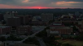 5.7K aerial stock footage stationary view of setting sun before flying by university campus, Austin, Texas Aerial Stock Footage | DX0002_105_034