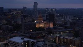 5.7K aerial stock footage of the state capitol lit up at twilight, office buildings and skyscrapers in Downtown Austin, Texas Aerial Stock Footage | DX0002_105_051