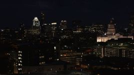 5.7K aerial stock footage ascend with view of skyscrapers, office buildings, Texas State Capitol at night in Downtown Austin, Texas Aerial Stock Footage | DX0002_106_014