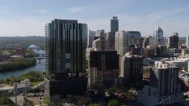5.7K aerial stock footage of the city's skyline behind high-rise near the water in Downtown Austin, Texas Aerial Stock Footage | DX0002_108_045