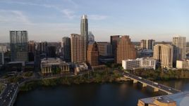 5.7K aerial stock footage of waterfront skyscrapers across Lady Bird Lake at sunset in Downtown Austin, Texas during descent Aerial Stock Footage | DX0002_110_005