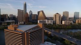 5.7K aerial stock footage fly away from waterfront skyscrapers across Lady Bird Lake at sunset, reveal hotel in Downtown Austin, Texas Aerial Stock Footage | DX0002_110_007