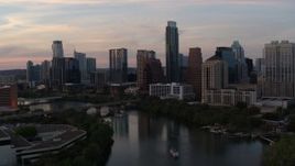 5.7K aerial stock footage of ascending over Lady Bird Lake toward the skyline at sunset in Downtown Austin, Texas Aerial Stock Footage | DX0002_110_017