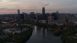 5.7K aerial stock footage of flying away from the skyline from over Lady Bird Lake at sunset in Downtown Austin, Texas Aerial Stock Footage | DX0002_110_019