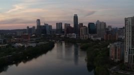 5.7K aerial stock footage focus on the skyline, descend toward Lady Bird Lake at sunset in Downtown Austin, Texas Aerial Stock Footage | DX0002_110_020