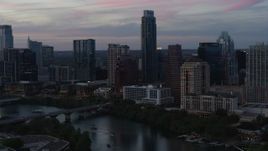 5.7K aerial stock footage reverse view of The Austonian and city skyline beside Lady Bird Lake at twilight in Downtown Austin, Texas Aerial Stock Footage | DX0002_110_029
