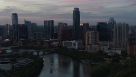 5.7K aerial stock footage of The Austonian towering over city skyline beside Lady Bird Lake at twilight in Downtown Austin, Texas Aerial Stock Footage | DX0002_110_030