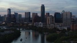 5.7K aerial stock footage of The Austonian at the center of city skyline seen from Lady Bird Lake at twilight in Downtown Austin, Texas Aerial Stock Footage | DX0002_110_032