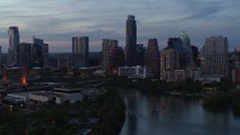 5.7K aerial stock footage of The Austonian and city skyline seen while passing over Lady Bird Lake at twilight in Downtown Austin, Texas Aerial Stock Footage | DX0002_110_033