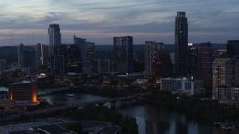 5.7K aerial stock footage fly away from the skyline by Lady Bird Lake and bridge at twilight in Downtown Austin, Texas Aerial Stock Footage | DX0002_110_038