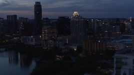 5.7K aerial stock footage of San Jacinto Center seen from Lady Bird Lake at twilight in Downtown Austin, Texas Aerial Stock Footage | DX0002_110_043