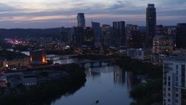 5.7K aerial stock footage reverse view of Congress Avenue Bridge, Lady Bird Lake, skyline at twilight in Downtown Austin, Texas Aerial Stock Footage | DX0002_110_044