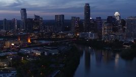 5.7K aerial stock footage fly over Lady Bird Lake, view of Congress Avenue Bridge and skyline at twilight in Downtown Austin, Texas Aerial Stock Footage | DX0002_110_046
