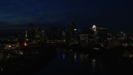 5.7K aerial stock footage of city's waterfront skyline on the opposite shore of Lady Bird Lake during descent at night in Downtown Austin, Texas Aerial Stock Footage | DX0002_111_015