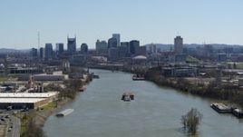 5.7K aerial stock footage a barge sailing the river toward the city's skyline, Downtown Nashville, Tennessee Aerial Stock Footage | DX0002_112_021