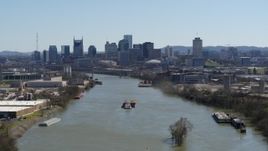 5.7K aerial stock footage passing by barge on the river toward the city's skyline, Downtown Nashville, Tennessee Aerial Stock Footage | DX0002_112_023
