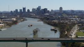 5.7K aerial stock footage a barge sailing the river toward the city's skyline, seen from a bridge, Downtown Nashville, Tennessee Aerial Stock Footage | DX0002_112_024