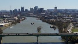 5.7K aerial stock footage flyby bridge with view of barge sailing toward city's skyline, Downtown Nashville, Tennessee Aerial Stock Footage | DX0002_112_027
