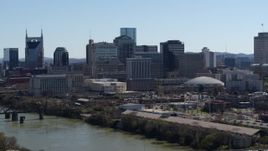 5.7K aerial stock footage of crossing the river, focus on the city's skyline, Downtown Nashville, Tennessee Aerial Stock Footage | DX0002_112_033