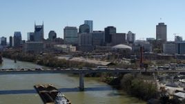 5.7K aerial stock footage of flying by city's skyline, reveal heavy traffic on bridge over the river, Downtown Nashville, Tennessee Aerial Stock Footage | DX0002_113_001