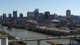 5.7K aerial stock footage ascend by heavy traffic on bridge over the river, focus on skyline, Downtown Nashville, Tennessee Aerial Stock Footage | DX0002_113_002