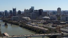5.7K aerial stock footage reverse view of skyline, reveal bridge spanning the river, Downtown Nashville, Tennessee Aerial Stock Footage | DX0002_113_003