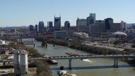 5.7K aerial stock footage focus on city skyline, reveal traffic on bridge spanning the river, Downtown Nashville, Tennessee Aerial Stock Footage | DX0002_113_005