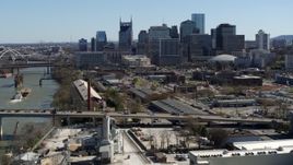 5.7K aerial stock footage a view of city's skyline while flying away from traffic on bridge over the river, Downtown Nashville, Tennessee Aerial Stock Footage | DX0002_113_008
