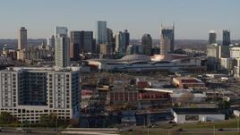 5.7K aerial stock footage fly away from the city skyline behind the convention center, descend by apartments in Downtown Nashville, Tennessee Aerial Stock Footage | DX0002_114_022