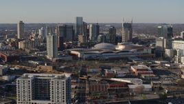 5.7K aerial stock footage of flying away from the city skyline behind the convention center in Downtown Nashville, Tennessee Aerial Stock Footage | DX0002_114_024