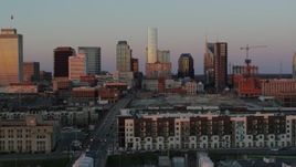 5.7K aerial stock footage descend near apartments, focus on city's skyline at sunset in Downtown Nashville, Tennessee Aerial Stock Footage | DX0002_115_011