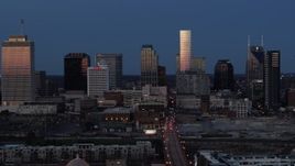 5.7K aerial stock footage descend while flying by skyscrapers reflecting light in the city skyline at twilight in Downtown Nashville, Tennessee Aerial Stock Footage | DX0002_115_027