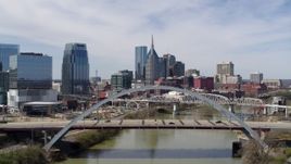 5.7K aerial stock footage descend near a bridge over the river with view of skyscrapers in Downtown Nashville, Tennessee Aerial Stock Footage | DX0002_116_008