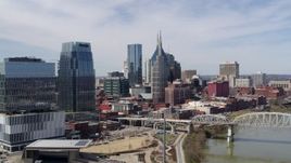5.7K aerial stock footage of flying by skyscrapers and reveal a bridge over the river in Downtown Nashville, Tennessee Aerial Stock Footage | DX0002_116_012