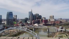 5.7K aerial stock footage of ascend from bridge to focus on skyscrapers across the river in Downtown Nashville, Tennessee Aerial Stock Footage | DX0002_116_013