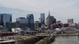 5.7K aerial stock footage of office high-rise and tall skyscrapers seen from near river and bridge in Downtown Nashville, Tennessee Aerial Stock Footage | DX0002_116_023