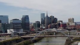 5.7K aerial stock footage of slowly passing a river and bridge, focus on skyscrapers in Downtown Nashville, Tennessee Aerial Stock Footage | DX0002_116_024