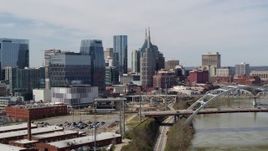 5.7K aerial stock footage of descending by the river and bridge, focus on skyscrapers in Downtown Nashville, Tennessee Aerial Stock Footage | DX0002_116_026