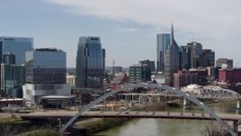 5.7K aerial stock footage fly away from river and bridge, office high-rise and skyscrapers in Downtown Nashville, Tennessee Aerial Stock Footage | DX0002_116_028