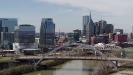 5.7K aerial stock footage reverse view of office high-rise and skyscrapers, reverse bridge on the river in Downtown Nashville, Tennessee Aerial Stock Footage | DX0002_116_032