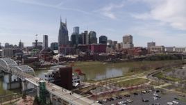 5.7K aerial stock footage fly toward the city's riverfront skyscrapers from the pedestrian bridge, Downtown Nashville, Tennessee Aerial Stock Footage | DX0002_117_005