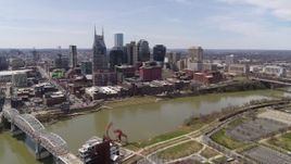 5.7K aerial stock footage approach the city's riverfront skyscrapers across the Cumberland River, Downtown Nashville, Tennessee Aerial Stock Footage | DX0002_117_007