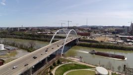 5.7K aerial stock footage of a barge sailing away from a bridge in Nashville, Tennessee Aerial Stock Footage | DX0002_117_014