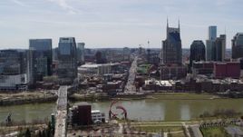 5.7K aerial stock footage descend while focused on busy Broadway across the Cumberland River, Downtown Nashville, Tennessee Aerial Stock Footage | DX0002_117_031
