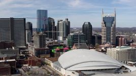 5.7K aerial stock footage of flying by Bridgestone Arena with a view of the skyline, Downtown Nashville, Tennessee Aerial Stock Footage | DX0002_117_043