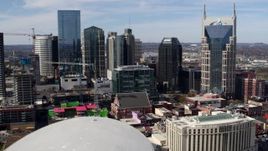5.7K aerial stock footage of flying away from the city's skyline, Bridgestone Arena, and Hilton hotel, Downtown Nashville, Tennessee Aerial Stock Footage | DX0002_117_048